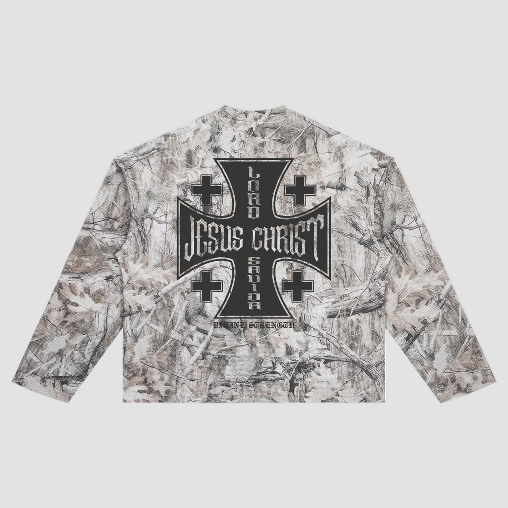 A long-sleeve crop top featuring a woodland camouflage pattern in shades of gray, beige, and brown, with a large black gothic-style cross graphic on the chest.